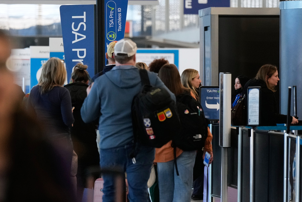Travelers wait in line to check in at a security checkpoint area at O'Hare International Airport, in Chicago, Sunday, Feb. 15, 2026. (AP Photo/Nam Y. Huh)
