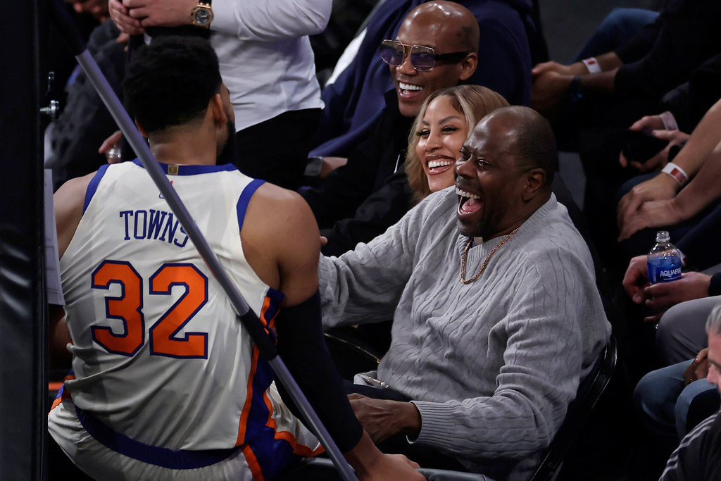 New York Knicks center Karl-Anthony Towns (32) reacts with former Knicks Patrick Ewing during the first half of an NBA basketball game against the Memphis Grizzlies, Tuesday, Nov. 11, 2025, in New York. (AP Photo/Adam Hunger)