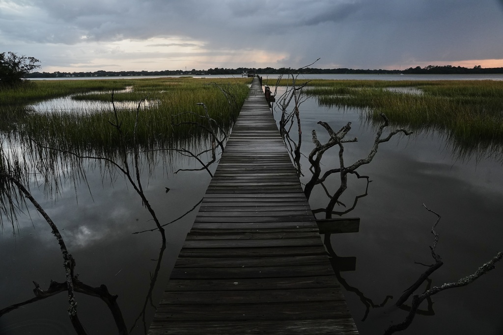 FILE- A storm moves through a salt marsh at sunset Monday, Oct. 6, 2025, in Charleston, S.C. (AP Photo/Joshua A. Bickel, File)