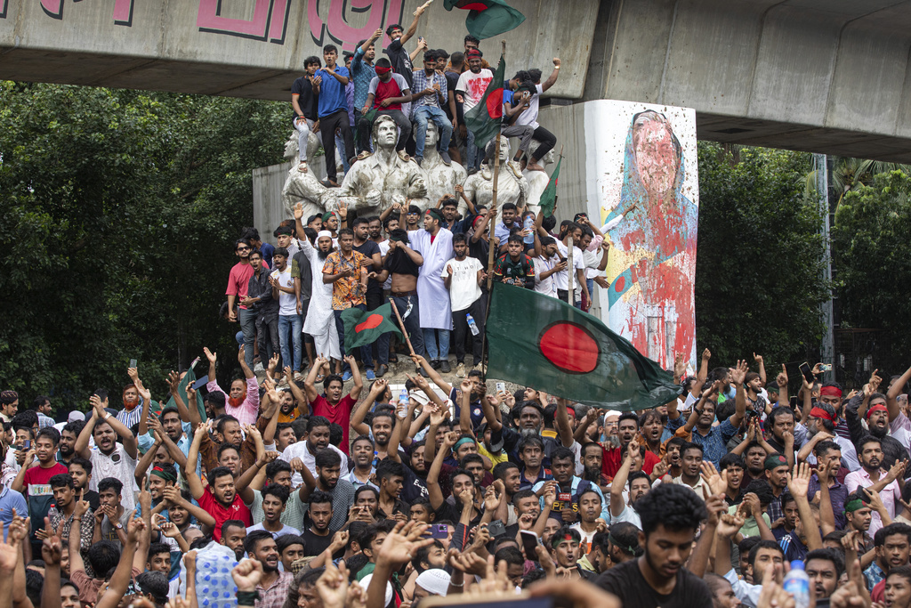 FILE -Protesters climb a public monument as they celebrate the news of Prime Minister Sheikh Hasina's resignation, in Dhaka, Bangladesh, Aug. 5, 2024. (AP Photo/Rajib Dhar, File)