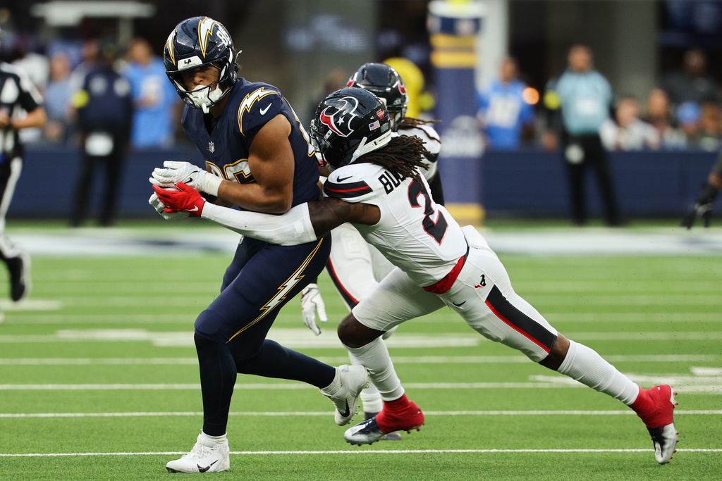 Los Angeles Chargers tight end Oronde Gadsden (86) is grabbed by Houston Texans safety Calen Bullock (2) during the second half of an NFL football game Saturday, Dec. 27, 2025, in Inglewood, Calif. (AP Photo/Kevork Djansezian)