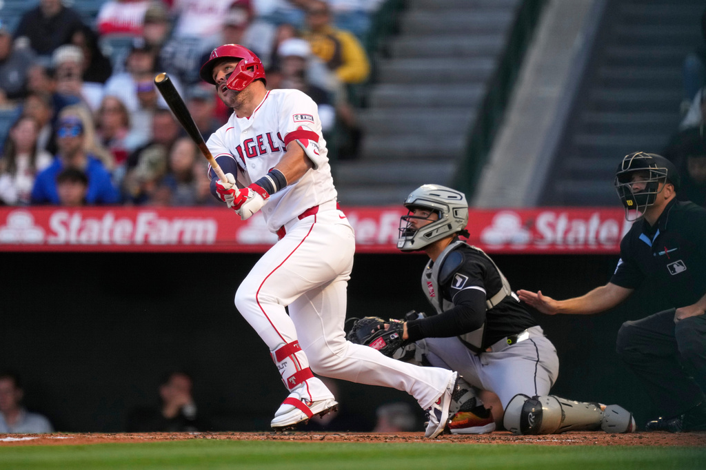 Los Angeles Angels' Mike Trout, left, heads to first for a solo home run as Chicago White Sox catcher Edgar Quero, center, and home plate umpire Jansen Visconti watch during the first inning of a baseball game Tuesday, May 5, 2026, in Anaheim, Calif. (AP Photo/Mark J. Terrill)