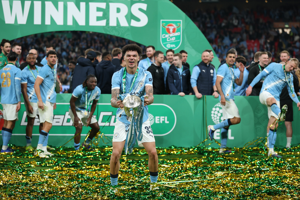 Manchester City's Nico O'Reilly celebrates with the trophy after winning the English League Cup final soccer match between Arsenal and Manchester City in London, Sunday, March 22, 2026. (AP Photo/Richard Pelham)
