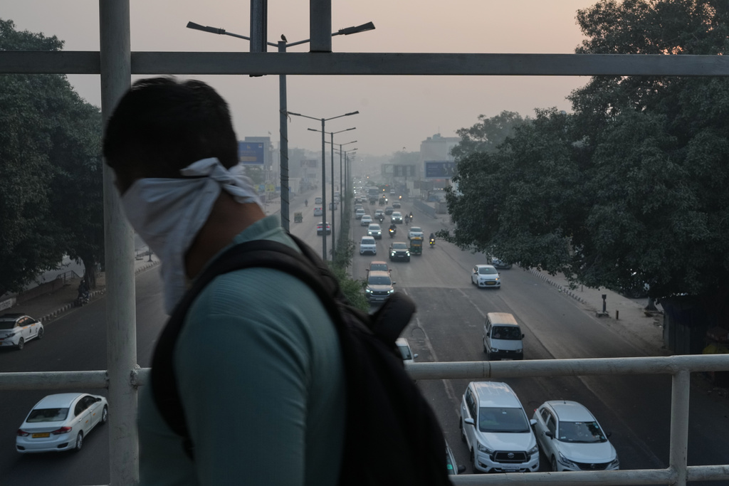 A man covers his face with a handkerchief as a shield from the air pollution on a smog-filled morning in New Delhi, India, Tuesday, Nov. 18, 2025. (AP Photo/Manish Swarup)