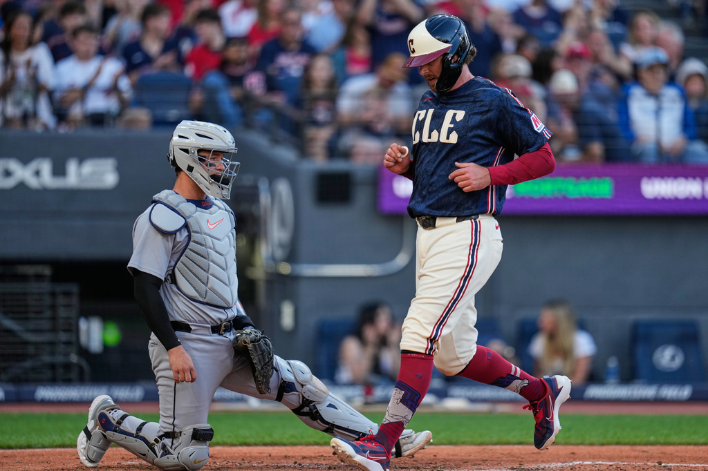 Cleveland Guardians' Rhys Hoskins, right, scores in front of Detroit Tigers catcher Dillon Dingler in the second inning of a baseball game in Cleveland, Friday, June 12, 2026. (AP Photo/Sue Ogrocki)