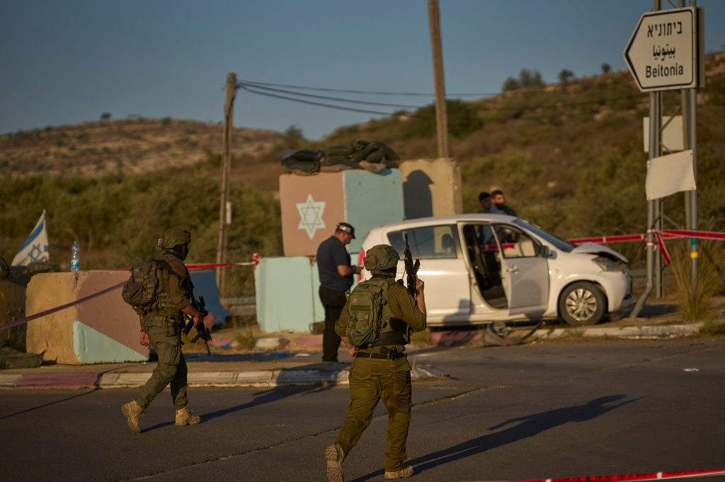 Israeli security forces inspect the scene where, according to police, a Palestinian man was shot and killed after ramming his car into a security checkpoint and seriously wounding an officer, near the West Bank Jewish settlement of Beit Horon, Wednesday, Sept. 23, 2026.(AP Photo/Ohad Zwigenberg)