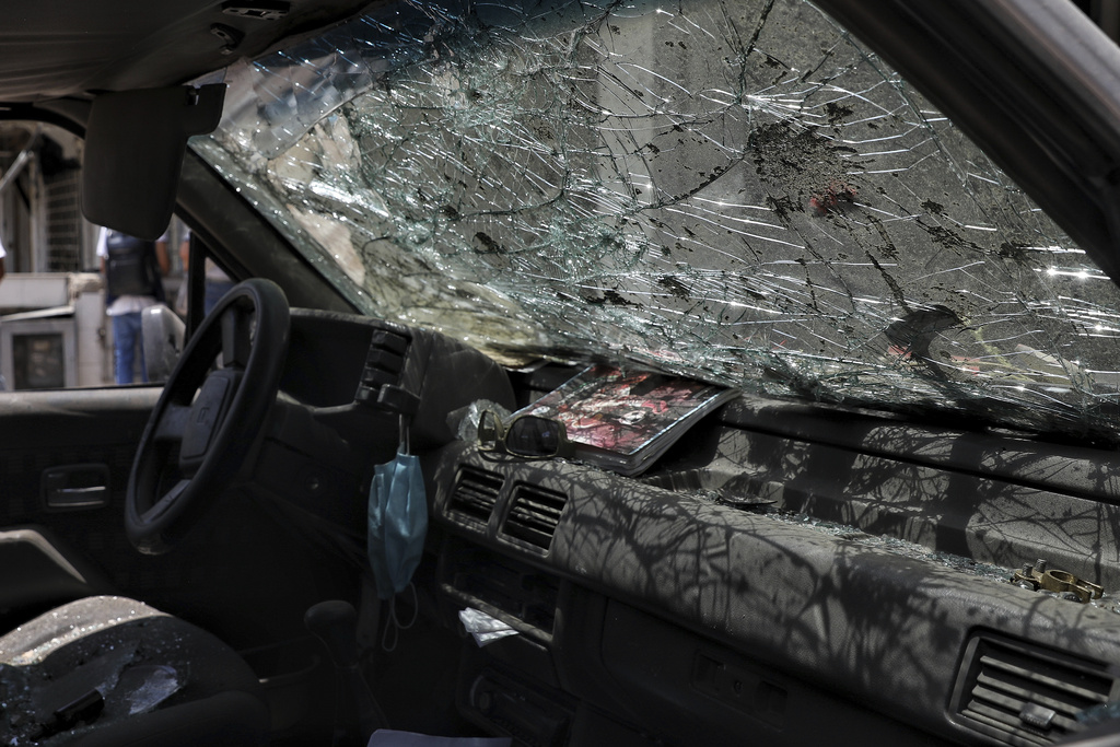 A car's windshield is shattered the day after a car bomb explosion outside an Air Force base in Cali, Colombia, Friday, Aug. 22, 2025. (AP Photo/Santiago Saldarriaga)