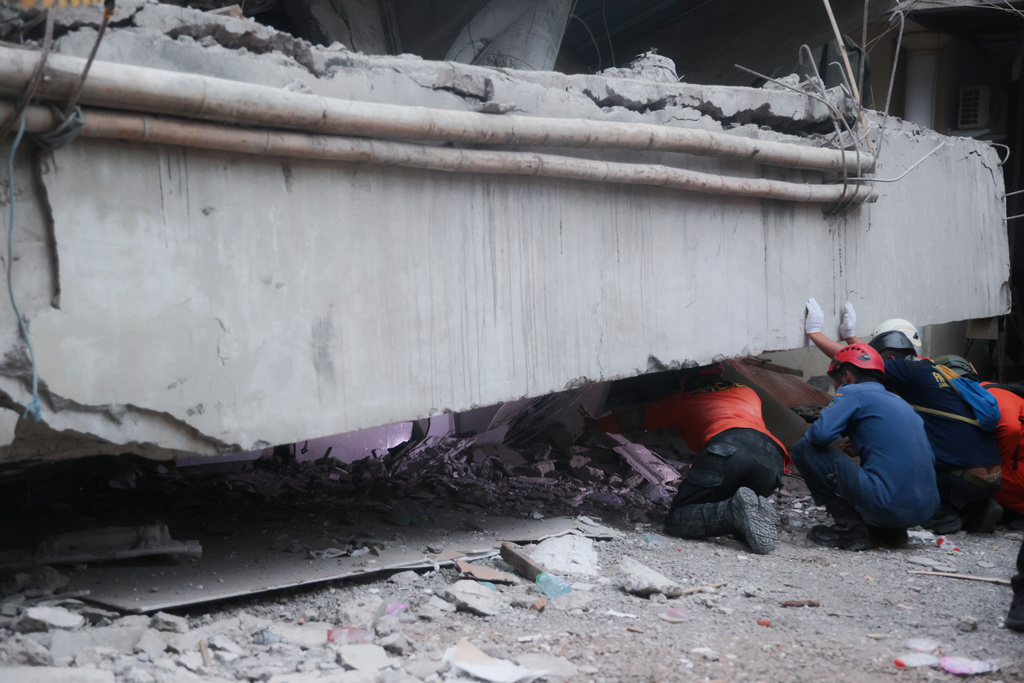 Rescuers search for victims at the site where a building under construction collapsed at an Islamic boarding school in Sidoarjo, East Java, Indonesia, Tuesday, Sept. 30, 2025. (AP Photo/Trisnadi)