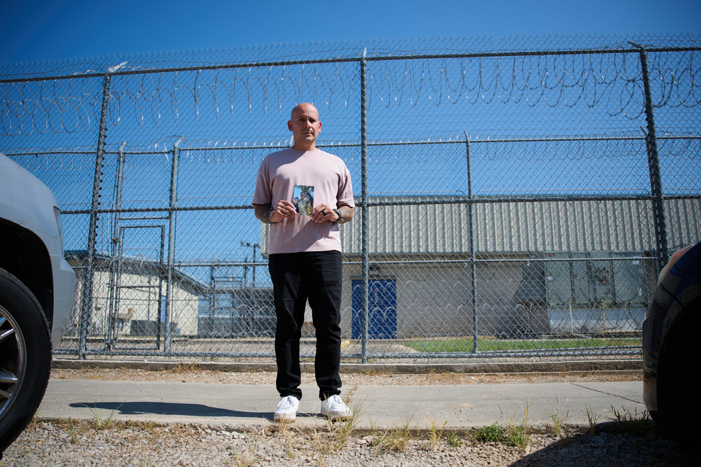 Army Staff Sgt. Alexis Jaramillo poses with a photo of his wife, Maisa Lopes Eliaser, a Brazilian national who is being detained by ICE, before visiting her at the South Louisiana ICE Processing Center in Basile, La., Sunday, Aug. 2, 2026. (AP Photo/Joseph Vidrine)