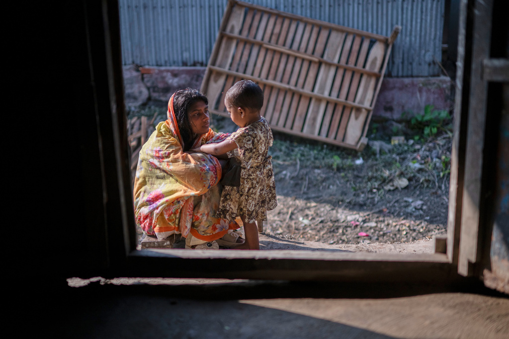 Meghna Rani, wife of Dipu Chandra Das, plays with her daughter outside their home in Tarakanda village, Mymensingh District, Bangladesh, Jan. 9, 2026. (AP Photo/Mahmud Hossain Opu)