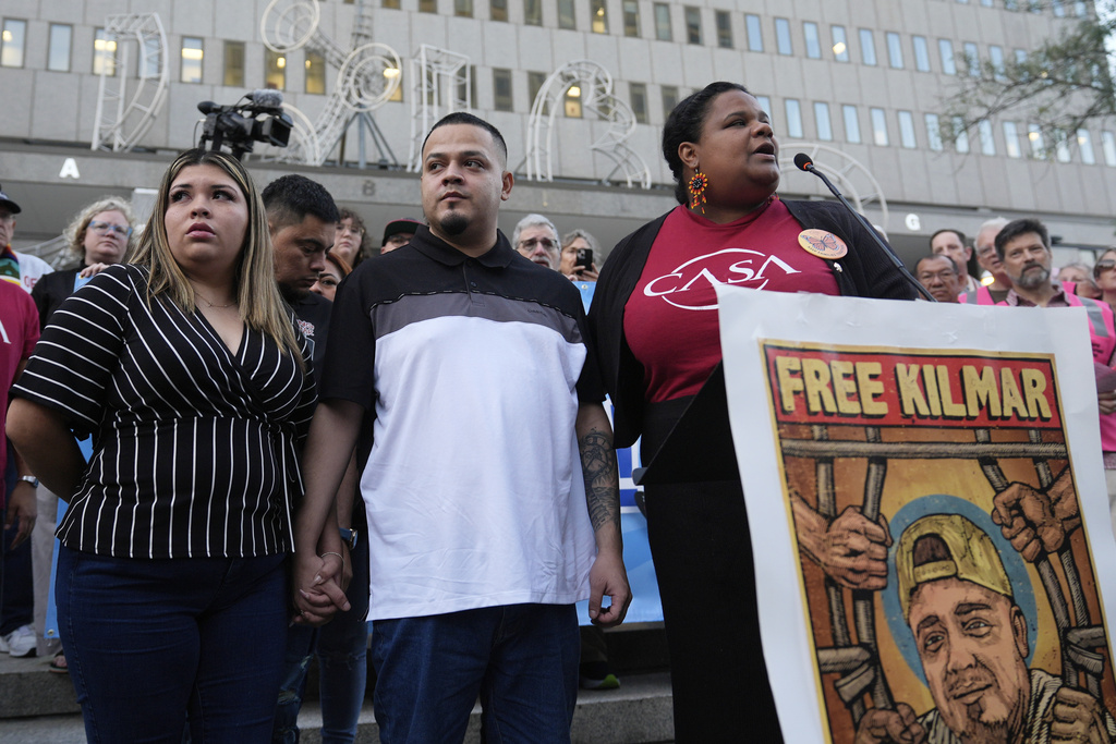 Jennifer Vasquez Sura, front left, and her husband Kilmar Abrego Garcia, front center, attend a protest rally at the Immigration and Customs Enforcement field office in Baltimore, Monday, Aug. 25, 2025, to support Kilmar Abrego Garcia. (AP Photo/Stephanie Scarbrough)