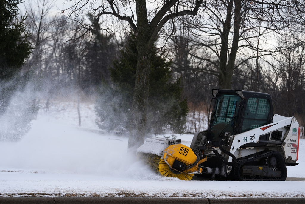 A plow clears snow from a snow-covered sidewalk during a cold day in Lake Forest, Ill., Wednesday, Jan. 21, 2026. (AP Photo/Nam Y. Huh)