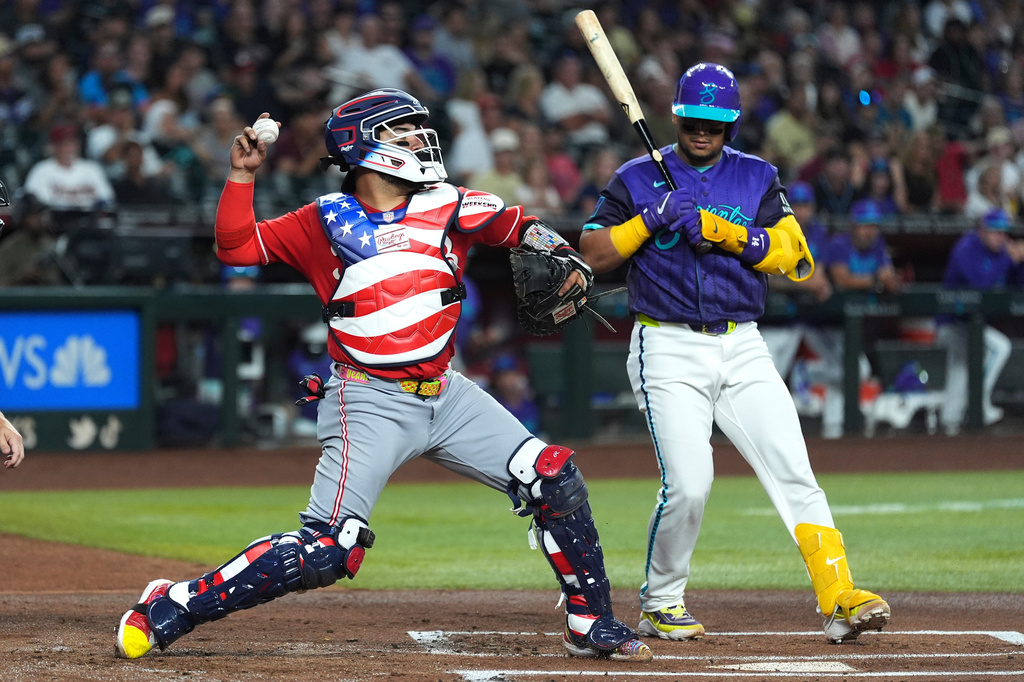 Cincinnati Reds catcher Jose Trevino, left, throws to second base as Arizona Diamondbacks' Gabriel Moreno looks on during the first inning of a baseball game, Friday, Aug. 21, 2026, in Phoenix. (AP Photo/Ross D. Franklin)