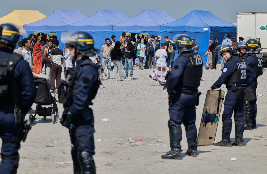 Police conduct a search operation at a makeshift camp of migrants who want to cross the English Channel to Britain near Dunkirk, northern France, Wednesday, May 27, 2026. (AP Photo/Jean-Francois Badias)