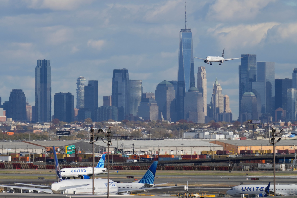 The New York City skyline is seen behind a plane approaching Newark International Airport in Newark, N.J., Thursday, Nov. 6, 2025. (AP Photo/Seth Wenig)