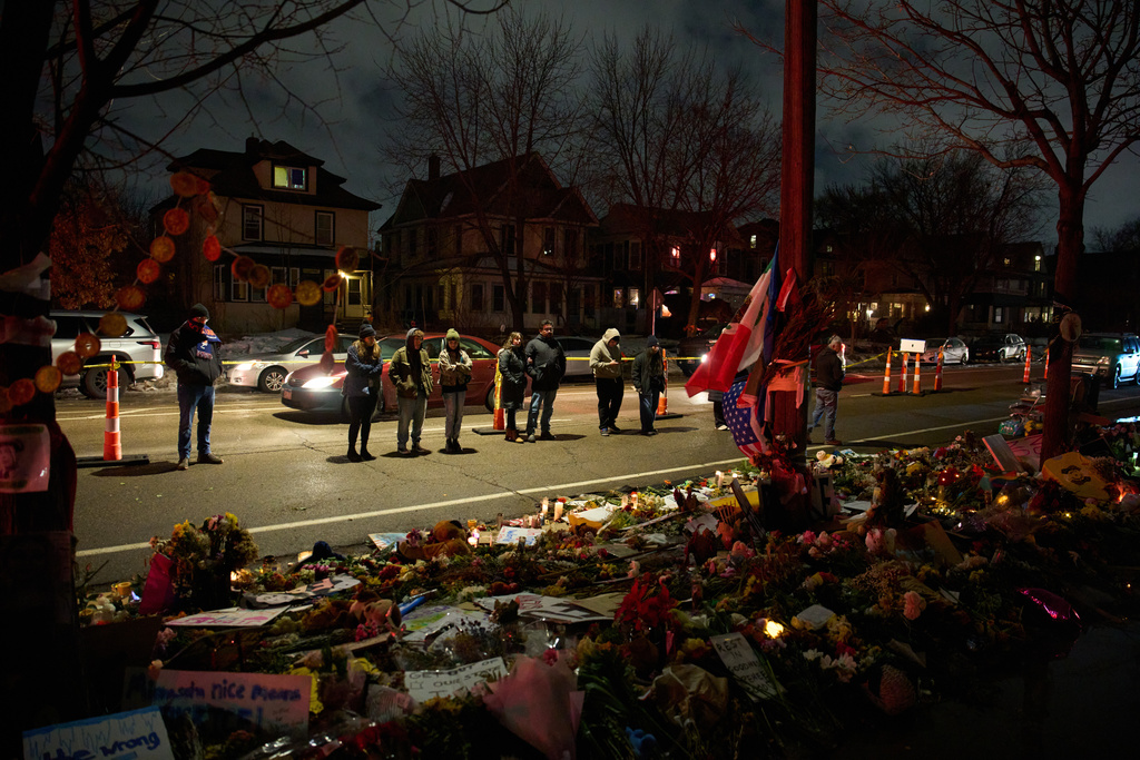 People visits a makeshift memorial for Renee Good, who was fatally shot by an ICE officer last week, Tuesday, Jan. 13, 2026, in Minneapolis. (AP Photo/John Locher)