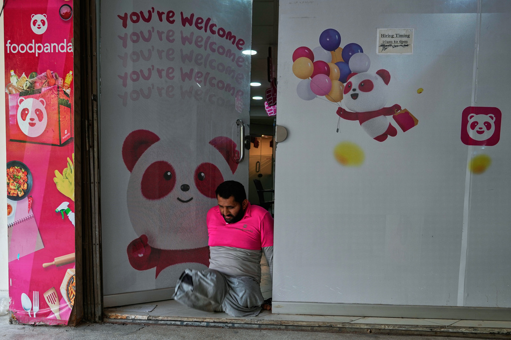 Hamza Ali, 28, who lost both legs in a road accident, leaves an office of foodpanda, a delivery platform, in Islamabad, Pakistan, Friday, July 17, 2026. (AP Photo/Anjum Naveed)