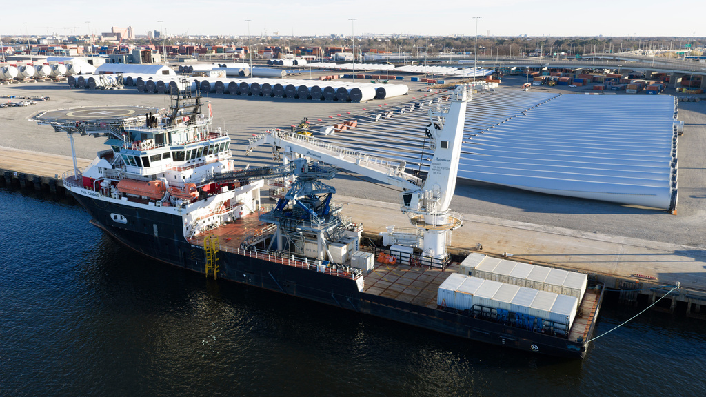 Wind turbine bases, generators and blades are positioned at The Portsmouth Marine terminal along with a support ship at the staging area for Dominion Energy's wind turbine project Monday Dec. 22, 2025, in Portsmouth, Va. (AP Photo/Steve Helber)