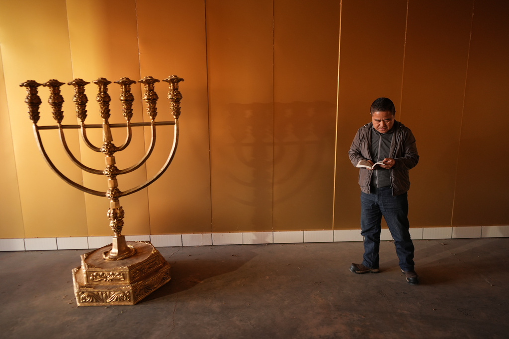 Former Chinese official Li Chuanliang holds a Bible as he prays inside the Mayflower Church temple sanctuary in Midland, Texas, Jan. 18, 2025. (AP Photo/Rebecca Blackwell)