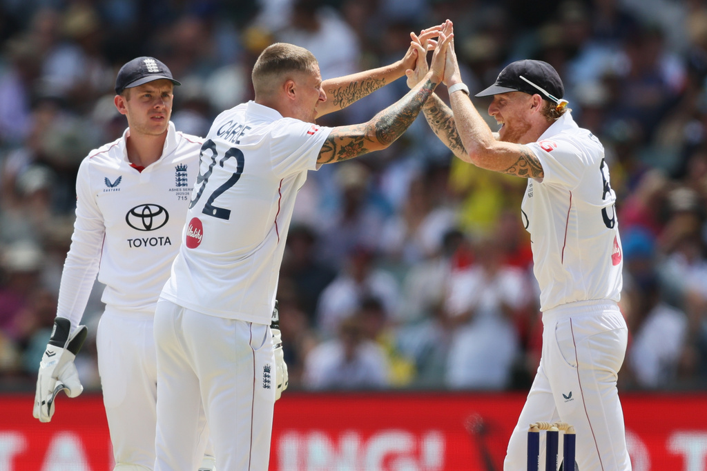 England's Brydon Carse, left, celebrates with Ben Stokes after dismissing Australia's Jake Weatherald, during play on day three of the third Ashes cricket test between England and Australia in Adelaide, Australia, Friday, Dec. 19, 2025. (AP Photo/James Elsby)