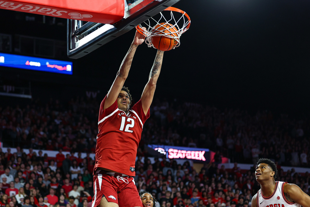 Arkansas forward Malique Ewin (12) dunks against Georgia forward Kareem Stagg, right, during the first half of an NCAA college basketball game, Saturday, Jan. 17, 2026, in Athens, Ga. (AP Photo/Colin Hubbard)