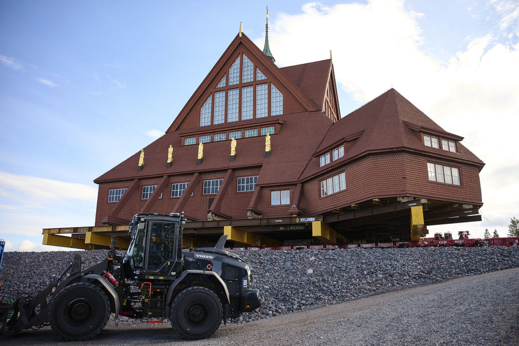 Construction machinery is parked next to the Kiruna Church, a Sami style wooden Swedish Lutheran church, called Kiruna Kyrka in Swedish, in Kiruna, Sweden, Wednesday, Aug. 20, 2025, after the completion of its move along a 5-km. (3-mile) route east to a new city center as part of the town's relocation.(AP Photo/Malin Haarala)