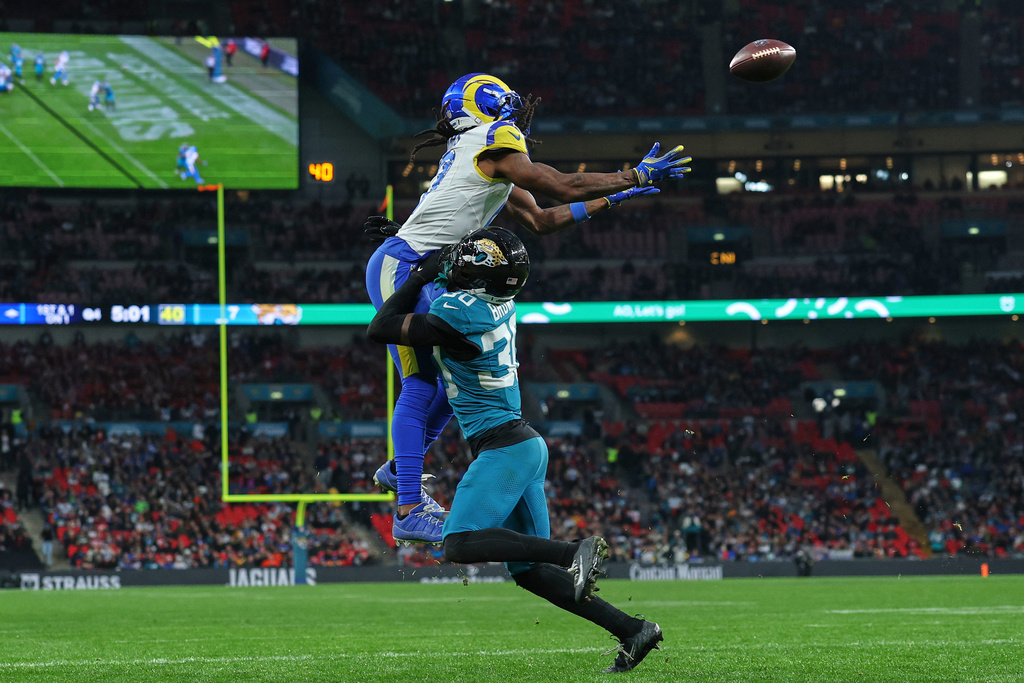 Los Angeles Rams wide receiver Davante Adams (17) leaps above Jacksonville Jaguars cornerback Montaric Brown (30) to score a touchdown during the second half of an NFL football game between the Los Angeles Rams and the Jacksonville Jaguars in London, Sunday, Oct. 19, 2025. (AP Photo/Ian Walton)