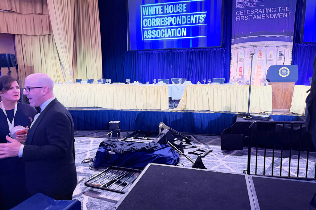 The empty stage is seen after President Donald Trump and other top leaders were evacuated from an annual dinner of White House correspondents on Saturday night, April 25, 2026, in Washington. (AP Photo/Zeke Miller)