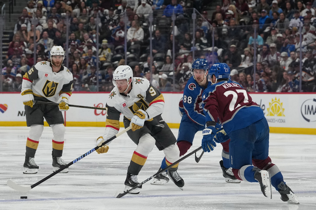Vegas Golden Knights center Jack Eichel (9) drives with the puck as Colorado Avalanche defenseman Brett Kulak (27) and center Martin Necas (88) defend while Golden Knights defenseman Noah Hanifin (15) trails the play during the second period in Game 2 of the Western Conference finals NHL hockey Stanley Cup playoff series Friday, May 22, 2026, in Denver. (AP Photo/David Zalubowski)