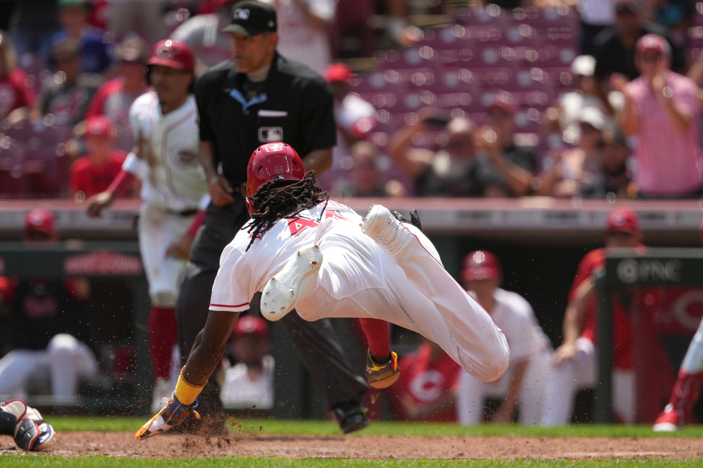 Cincinnati Reds' Elly de la Cruz goes airborne while sliding in to score during the fourth inning in the first baseball game of a doubleheader against the Cleveland Guardians, Tuesday, July 28, 2026, in Cincinnati. (AP Photo/Kareem Elgazzar)