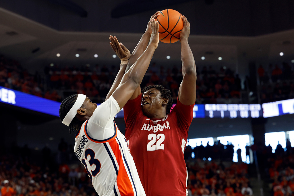 Alabama forward Aiden Sherrell (22) puts up a shot over Auburn guard CJ Williams (13) during the first half of an NCAA college basketball game Saturday, Feb. 7, 2026, in Auburn, Ala. (AP Photo/Butch Dill)