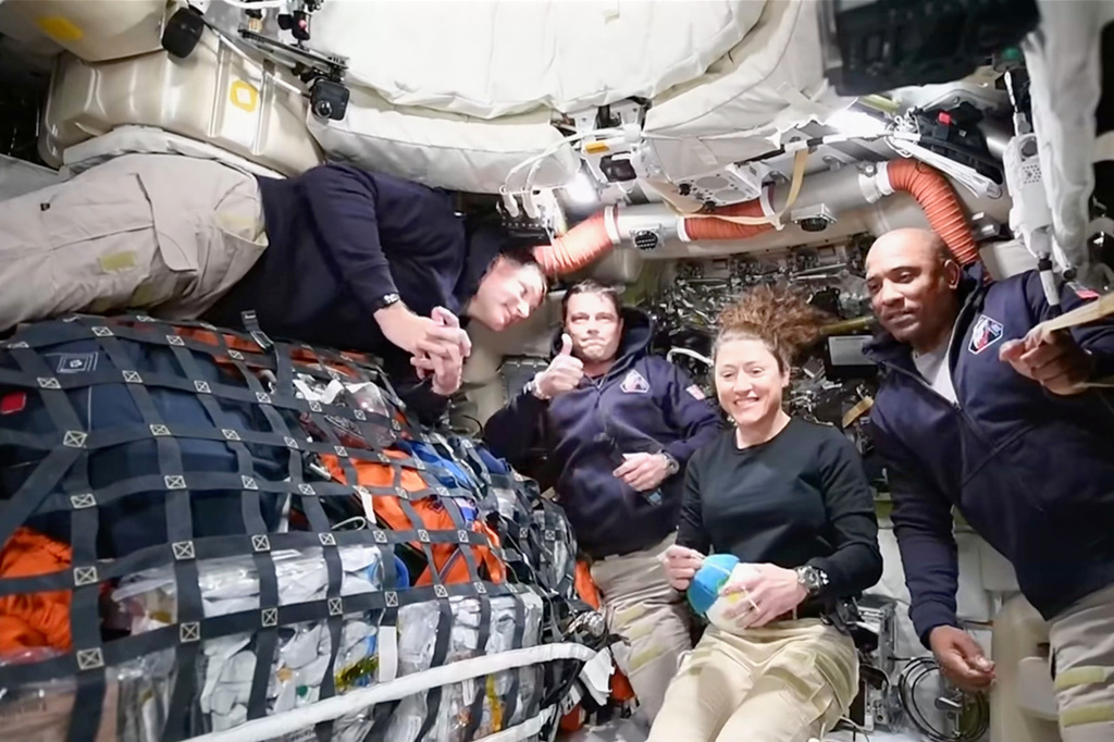 This image from video provided by NASA shows the Artemis II crew, from left, Canadian astronaut and mission specialist Jeremy Hansen, Commander Reid Wiseman, mission specialist Christina Koch and pilot Victor Glover as they speak with NASA Mission Control in a video conference while en route to the moon, Thursday, April 2, 2026. (NASA via AP) CORRECTION: headed to the moon, not in moon's orbit