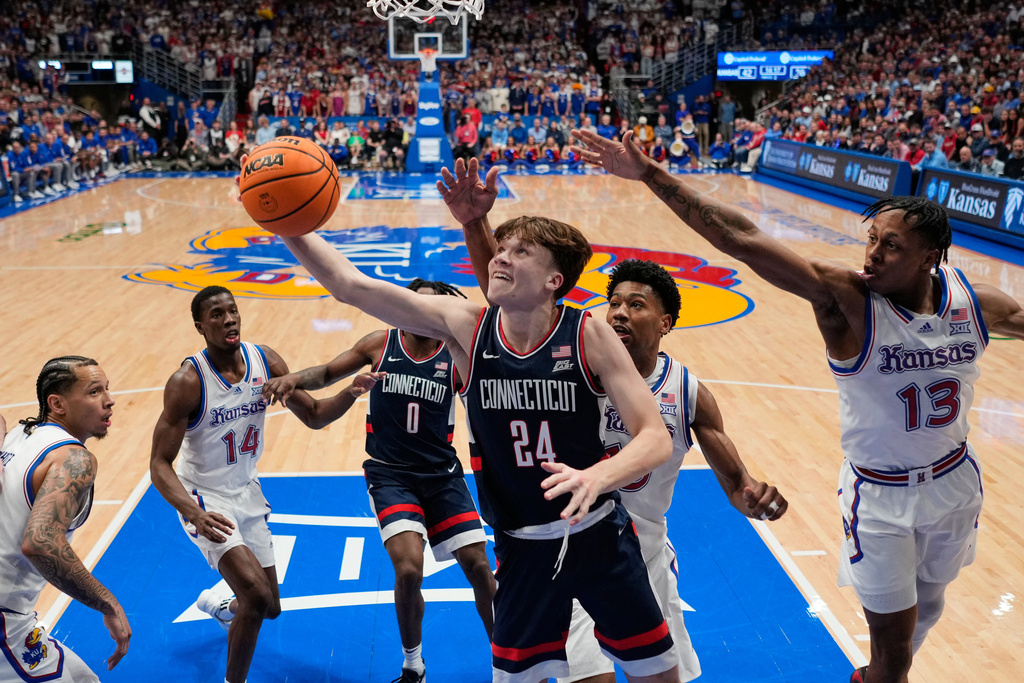 UConn guard Braylon Mullins (24) puts up a shot during the second half of an NCAA college basketball game against Kansas, Tuesday, Dec. 2, 2025, in Lawrence, Kan. (AP Photo/Charlie Riedel)