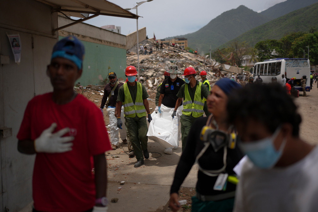 Rescue workers and forensic technician Joel Mirabal, back left, recover the body of an earthquake victim in La Guaira, Venezuela, Tuesday, June 30, 2026. (AP Photo/Matias Delacroix)