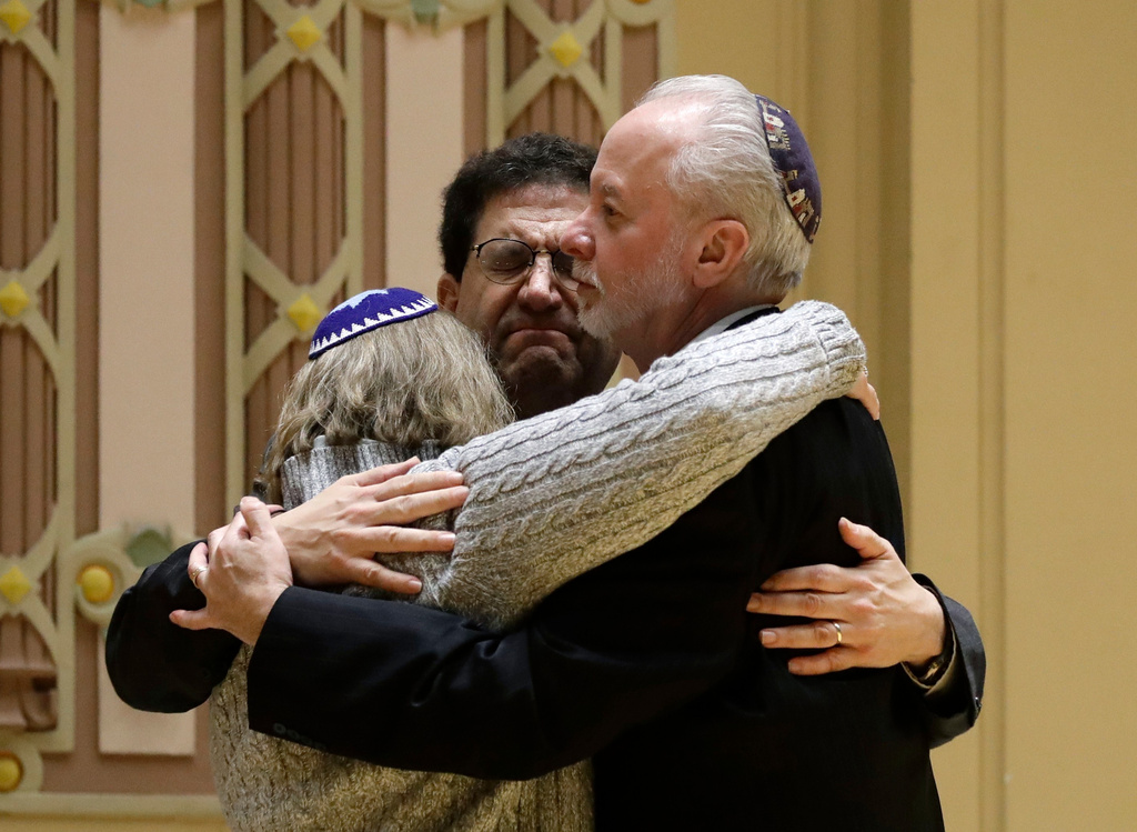FILE - Rabbi Jeffrey Myers, right, of Tree of Life/Or L'Simcha Congregation hugs Rabbi Cheryl Klein, left, of Dor Hadash Congregation and Rabbi Jonathan Perlman during a community gathering held in the aftermath of a deadly shooting at the Tree of Life Synagogue in Pittsburgh, on Oct. 28, 2018. Perlman took shelter in a supply closet with three members of his New Light congregation during the attack. (AP Photo/Matt Rourke, File)