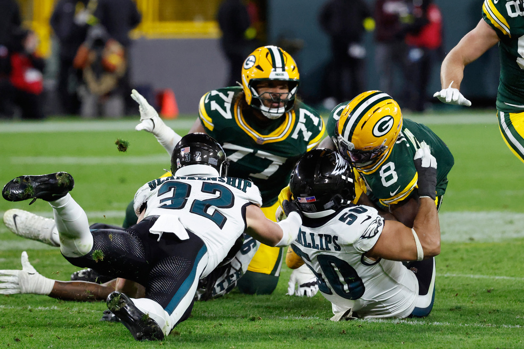 Philadelphia Eagles linebacker Jaelan Phillips (50) forces a fumble by Green Bay Packers running back Josh Jacobs (8) during the second half of an NFL football game Monday, Nov. 10, 2025, in Green Bay, Wis. (AP Photo/Mike Roemer)