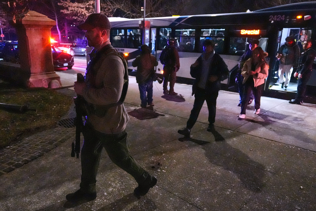 Students are escorted by law enforcement officers to a building at Brown University after a shooting, Saturday, Dec. 13, 2025, in Providence, R.I.. (AP Photo/Charles Krupa)