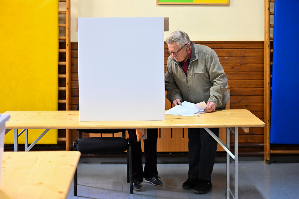 A couple fills out the ballot at a polling station for parliamentary elections in Arnace, Slovenia, on Sunday, March 22, 2026. (AP Photo/Denes Erdos)