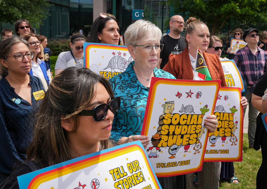 Karen Prewitt of Mission holds a sign reading "Social studies rules" during a rally on the Capitol Mall outside the Barbara Jordan State Office Building, where the State Board of Education meets, Tuesday, April 7, 2026, in Austin, Texas. (Jay Janner/Austin American-Statesman via AP)