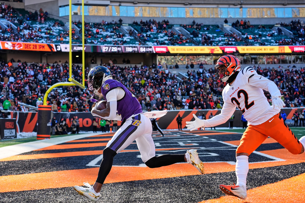 Baltimore Ravens wide receiver Zay Flowers, left, makes a catch for a touchdown past Cincinnati Bengals safety Geno Stone (22) during the first half of an NFL football game, Sunday, Dec. 14, 2025, in Cincinnati. (AP Photo/Carolyn Kaster)
