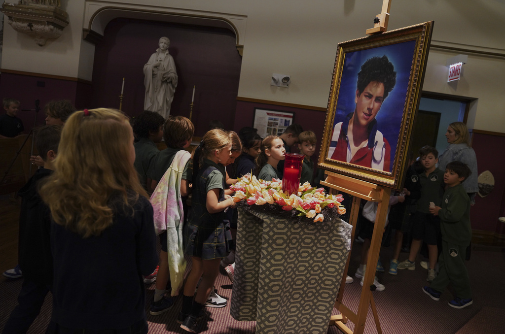 Students of St. John Berchmans' school walk past a photo of Blessed Carlo Acutis, who will be canonized a saint by Pope Leo XIV, after Mass at Blessed Carlo Acutis Parish, on Wednesday, Sept. 3, 2025, in Chicago. (AP Photo/Jessie Wardarski)