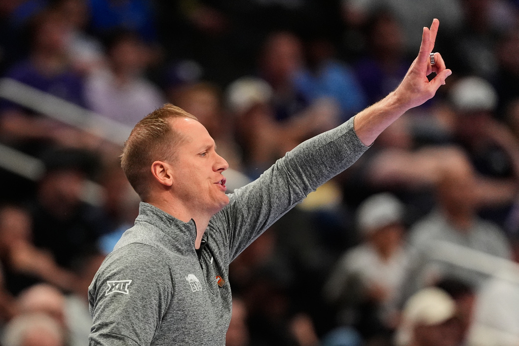 BYU head coach Kevin Young talks to his players during the first half of an NCAA college basketball game against Kansas State, at the Big 12 Conference tournament Tuesday, March 10, 2026, in Kansas City, Mo. (AP Photo/Charlie Riedel)