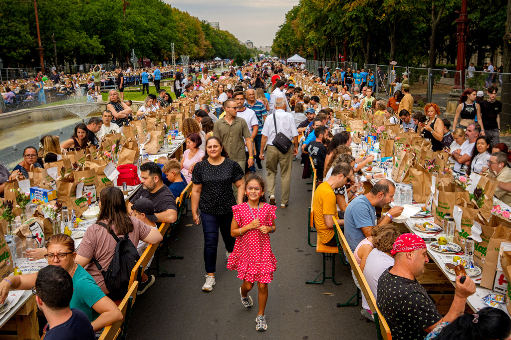 People walk along a 5-kilometer (3.1 miles) long "Uniting Table", made from recycled materials, during a Guinness World Record event to raise money for a children's psychiatric facility, in Bucharest, Romania, Saturday, Sept. 12, 2026. (AP Photo/Andreea Alexandru)