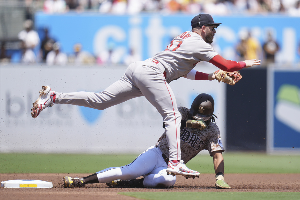 Boston Red Sox shortstop Trevor Story, above, watches his throw to first for the double play as San Diego Padres' Fernando Tatis Jr. slides in late to second during the first inning of a baseball game Sunday, Aug. 10, 2025, in San Diego. San Diego Padres' Luis Arraez was out at first on the play. (AP Photo/Gregory Bull)