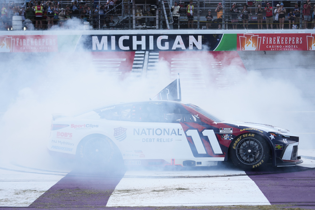Denny Hamlin celebrates with a burnout after winning a NASCAR Cup Series auto race at Michigan International Speedway in Brooklyn, Mich., Sunday, June 7, 2026. (AP Photo/Paul Sancya)