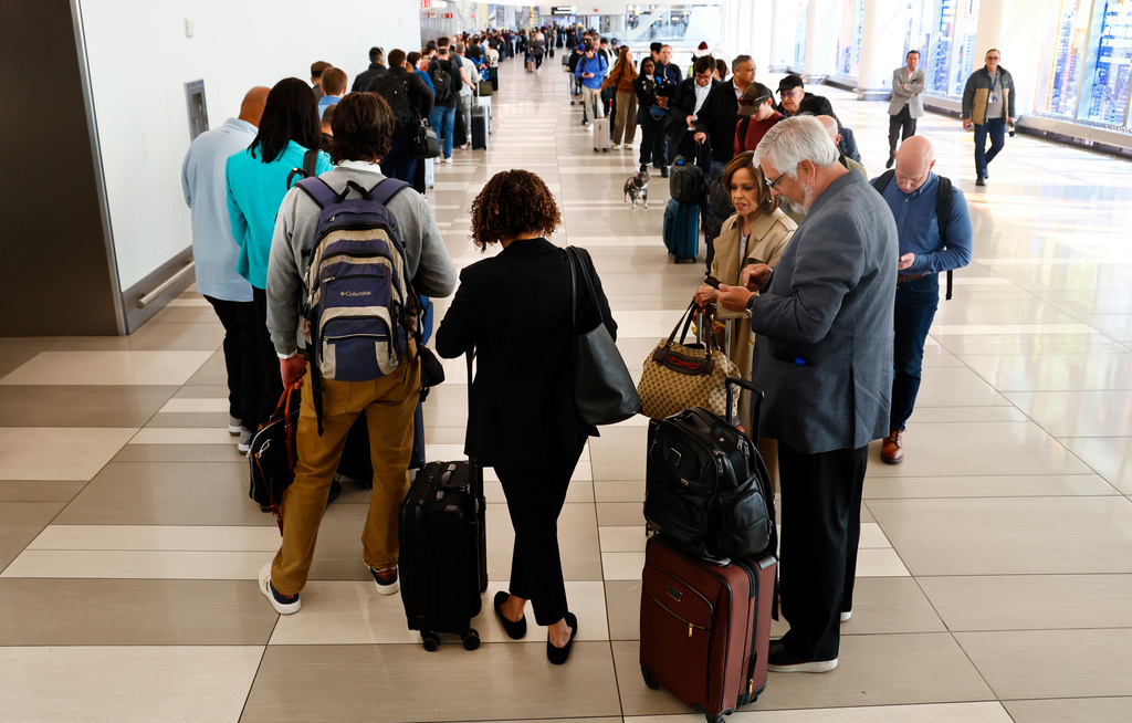 Passengers stand in the TSA pre-check line at LaGuardia Airport, Thursday, March 26, 2026, in New York. (AP Photo/Noah K. Murray)