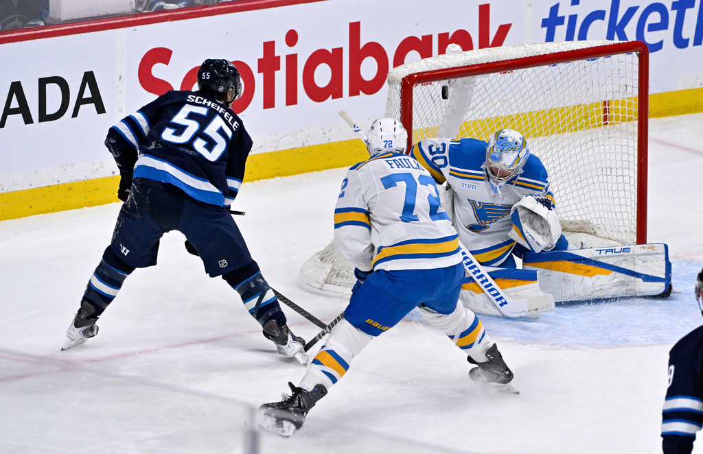 Winnipeg Jets' Mark Scheifele (55) scores on St. Louis Blues' goaltender Joel Hofer (30) during the first period of an NHL hockey game in Winnipeg, Tuesday Jan. 20, 2026. (Fred Greenslade/The Canadian Press via AP)