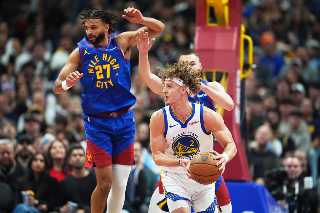 Golden State Warriors guard Brandin Podziemski, front, looks to pass the ball as Denver Nuggets guards Jamal Murray, back left, and Christian Braun defend in the first half of an NBA Cup basketball game Friday, Nov. 7, 2025, in Denver. (AP Photo/David Zalubowski)