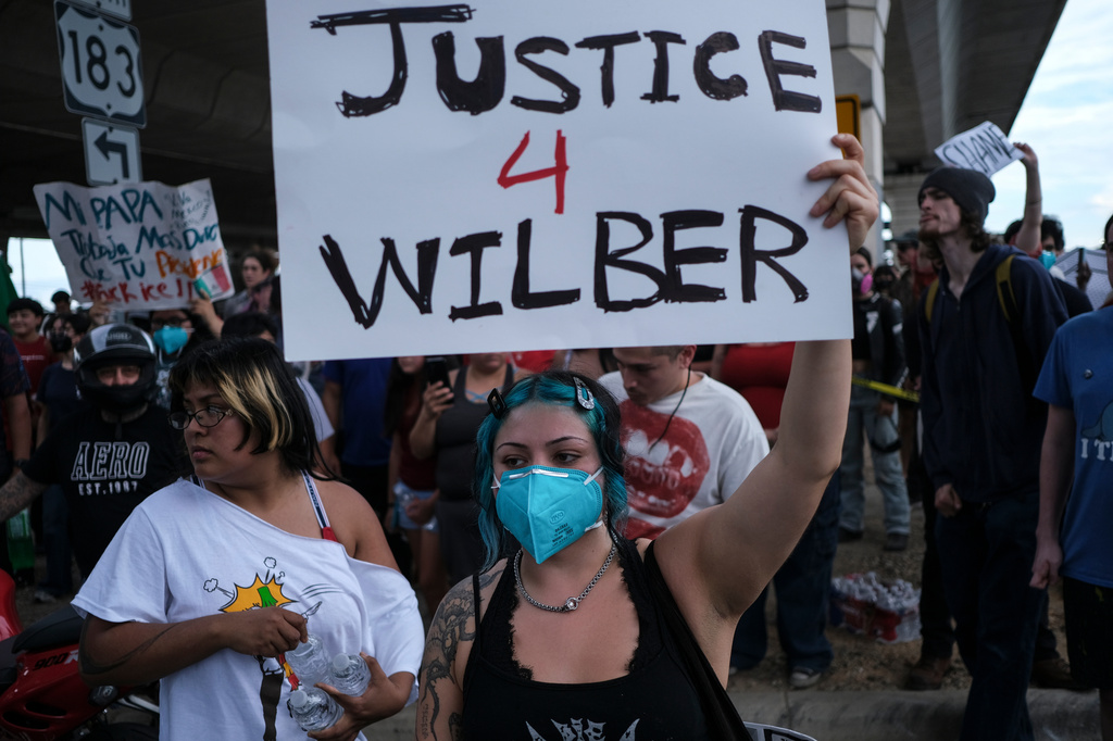 People speak during a demonstration where a man was shot in his vehicle by an ICE officer, Sunday, Sept. 20, 2026, in Austin, Texas. (AP Photo/Joel Angel Juarez)