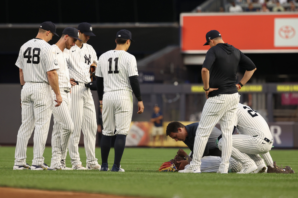 New York Yankees players and staff check on Jazz Chisholm Jr., bottom right, during the fourth inning of a baseball game against the Detroit Tigers, Monday, June 29, 2026, in New York. (AP Photo/Pamela Smith)
